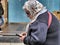 Aged woman consulting her smartphone