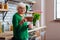 Aged woman looking at picture frame and enjoying morning coffee