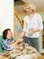 Aged woman offering pills and water to pensioner