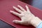 Aged woman right hand with lilac manicure lays on the needle applicator.