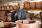 Aged woman selecting decorative earthenware pot in shop