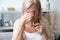 Aged woman taking off glasses rubbing eyelid suffers from eyestrain