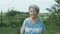 Aged woman walking in the park of garden