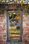 Aged wooden door of an abandoned house surrounded by a colorful array of autumn leaves