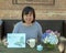 Ageless Asian mother celebrating Mother`s Day with flowers, card and a surprise gift in the box.