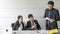 Aggressive boss businessman holding paper file work and complain staff and colleague in meeting conference room