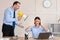 Aggressive Businessman Shouting At Woman Holding Megaphone Standing In Office