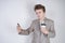 Aggressive caucasian teenager screams into the smart phone and holds a paper cup of coffee in his hand. student on edge on a white