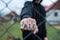 Aggressive teenage boy showing hes fist behind wired fence at the correctional institute, the word hate is written on hes hand