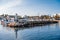 AGIA NAPA, CYPRUS - April 3, 2016: Entrance to the little port with fishing and cruise boats, people resting near the beacon