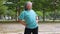 Aging mature woman do fitness outdoors in park at morning, fitness concept Taking care of the physical health of the elderly.