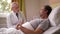 Aging physician examining sick male lying in ward