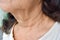 Aging skin folds or skin creases or wrinkles at neck of Asian, Chinese elderly woman