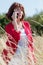 Aging woman thinking on phone in high summer field flowers