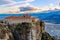 Agios Stephanos or Saint Stephen monastery located on the huge rock with mountains and town landscape in the background, Meteors,