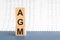 AGM Annual general meeting acronym on wooden cubes on grey backround. Business concept