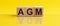 AGM - Annual general meeting - acronym on wooden cubes on yellow backround. Business concept