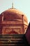 Agra, India : Islamic style red stone dome style architecture monument with squirrel on stairs against clear sky