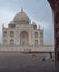 AGRA, INDIA - MARCH, 26, 2019 early morning view of the taj mahal, framed by an arch, with a mischievous monkey