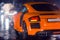 Agressive and brutal orange sport car on rained road picture useful for background