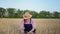 Agribusiness, elderly male farmer in straw hat with ears of wheat in hands sits down in wheat field