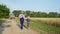 Agribusiness, elderly male farmer walks hand in hand with his grandson