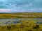 Agricultural barren land with crops harvested and sky turned greenish blue