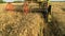 An agricultural combine cutting and harvesting wheat.