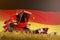 Agricultural combine harvester working on rural field with Germany flag background, food production concept - industrial 3D