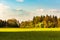 Agricultural field and forest landscape in Austria. Green trees on beginning of spring