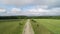 Agricultural fields, countryside. A dirt rural road running through green fields.