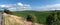 Agricultural fields on hills by the road in Bohemia, Czesh Republic. Panoramic image taken by the road on a bright day