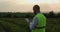 Agricultural industry. A male farmer with a digital tablet in a field at sunset. Agronomist uses technologies in the