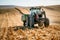 Agricultural industy - Industrial Tractor with trailer working the corn fields and harvesting during fall season