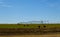 Agricultural irrigation system watering field on sunny day