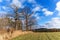 Agricultural landscape and blue sky. Morning in the countryside. Meadow and trees. Idilic landscape. Climate change