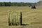 Agricultural machinery in the fields packs mowed straw for livestock farms