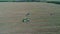 Agricultural machinery during harvest, July day aerial video