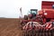 Agricultural machinery on a spring day during the sowing of spring grain crops against the background of a plowed field