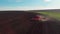 Agricultural modern tractor plough plows ground before planting the crop, preparing soil for sowing, view from the drone