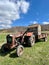 Agricultural red tractor with trailer. Faded paint, retro.