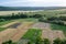 Agricultural Rolling Spring Autumn Landscape. Natural Landscape In Brown And Yellow Color. Waved Cultivated Row Field And Tree.