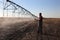 Agricultural scene, farmer inspecting irrigation sytem in field