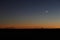 An agricultural sprinkler system silhouetted against a late sunset.