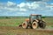 An agricultural tractor driving in the field