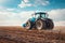 An agricultural tractor driving in the field