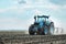 An agricultural tractor driving in the field