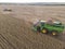 Agricultural tractor harvesting soybeans in the field