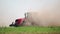 Agricultural tractor prepares dusty soil affected by drought