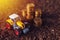 Agricultural tractor toy and golden coins on fertile soil land